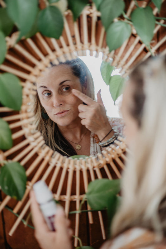women applying serum in mirror